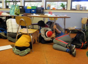 Drop, cover and hold was just the beginning for a drill at Sunnyside Environmental K-8 School last Wednesday. TOM BANSE / N3