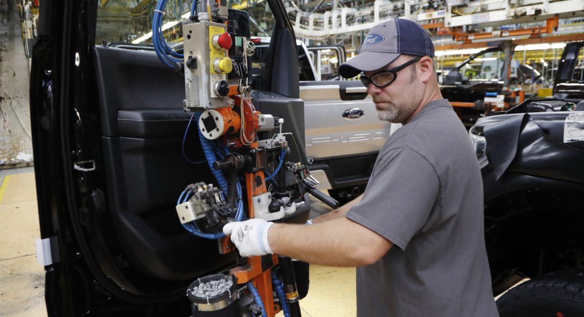 A worker installs a door on a 2018 Ford F-150 truck at an assembly plant in Dearborn, Mich., on Sept. 27. The U.S. unemployment rate fell to 3.7 percent in September, a nearly 50-year low. CREDIT: Carlos Osorio/AP