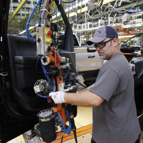 A worker installs a door on a 2018 Ford F-150 truck at an assembly plant in Dearborn, Mich., on Sept. 27. The U.S. unemployment rate fell to 3.7 percent in September, a nearly 50-year low. CREDIT: Carlos Osorio/AP