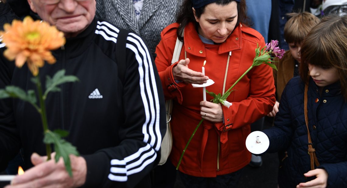 People pay their respects in front of a memorial on Sunday outside of the Tree of Life synagogue in Pittsburgh after a shooting there on left 11 people dead.