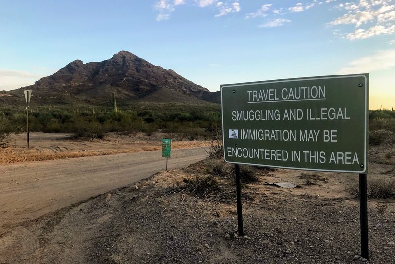 A sign outside Ajo, Ariz., warns hikers to keep an eye out for people who have unlawfully crossed the nearby border with Mexico. No More Deaths and other humanitarian groups use a private residence they call "the barn" on the outskirts of the small town as a base of operations. CREDIT: RYAN LUCAS/NPR