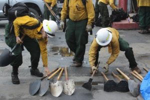 Firefighters with the private contracting outfit Inbound LLC stack shovels and other hand tools at the company’s headquarters in Oakridge, Oregon.  CREDIT: TONY SCHICK