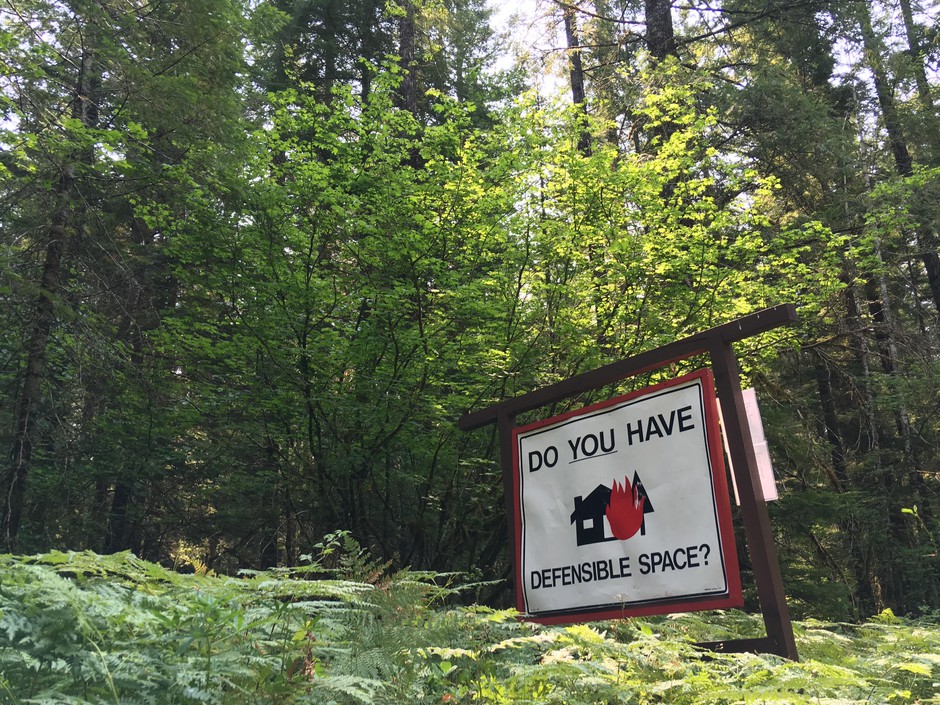 A roadside reminder in southwest Washington's Gifford Pinchot National Forest that homes in the "wildlands urban interface" need special landscaping, building materials and maintenance to reduce the risk of being destroyed by a wildfire. CREDIT: CASSANDRA PROFITA