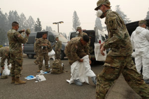 Members of the California Army National Guard put on protective suits before searching for victims of the Camp Fire in Paradise, Calif., on Wednesday, Nov. 15, 2018. CREDIT: John Locher/AP