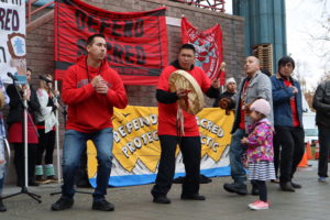 Samuel Johns, center, attended a rally and gathered signatures from fellow Alaska native men last month. The pledge asks men to take action against violence against native women. CREDIT: EMILY SCHWING/N3