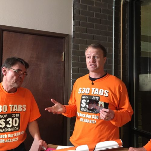 Professional initiative sponsor Tim Eyman, right, holds a photo from his first successful $30 car tabs initiative in 1999. Eyman says he has collected almost enough signatures to qualify a 2019 car tabs rollback initiative to the 2019 Legislature. CREDIT: AUSTIN JENKINS/N3