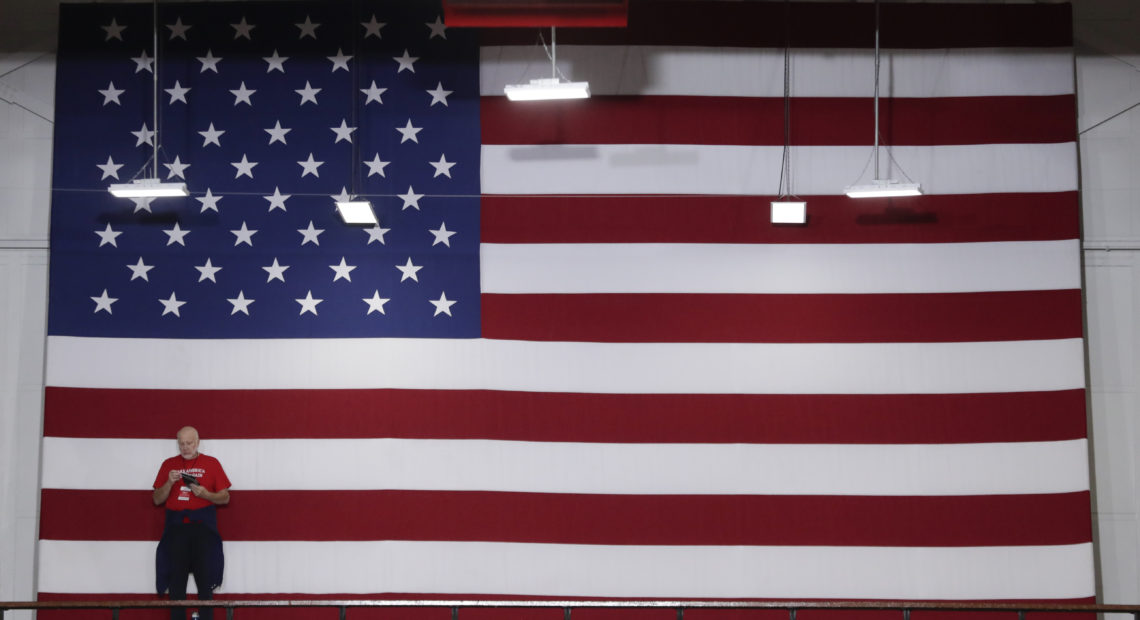 A volunteer stands in front of an American flag before President Trump speaks at a rally last week in Indianapolis. Indiana is a key Senate battleground state for the GOP.