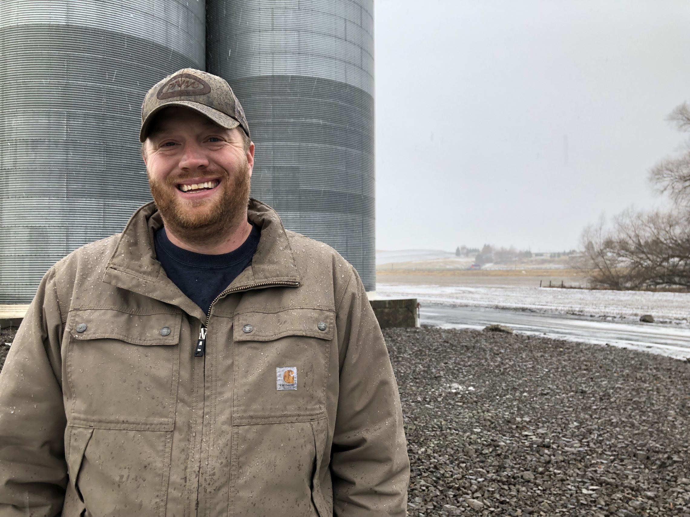 Allen Druffel, 34, of Colton, Wash., stands in front of the co-op silos that hold his unsold chickpeas. Last year he was getting 50 cents a pound for his pulse crop. Now, the going price is 18 cents a pound -- well below his cost of production.