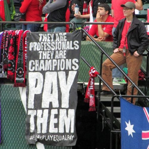 In this photo taken May 21, 2016, a sign calling for equitable pay in soccer is displayed at a Portland Thorns women’s soccer game at Providence Park in Portland. CREDIT: Anne M. Peterson/AP