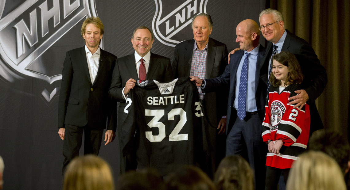 NHL commissioner Gary Bettman (center left) presents a jersey with No. 32, signifying that Seattle is soon to be the NHL's 32nd active franchise. The NHL Board of Governors announced the expansion Tuesday. CREDIT: STEPHEN B. MORTON/AP