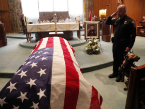 As of Dec. 27, this year 144 federal, state and local law enforcement officers have died in the line of duty — a rise from the 129 officers killed in 2017. Here, wounded Dekalb County Police K9 Indi stands by his handler's side during a funeral service for Edgar Flores on Dec. 18 in Georgia. CREDIT: John Bazemore/AP