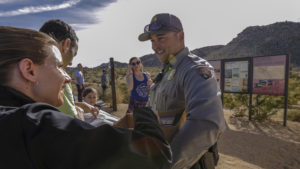 Lone park ranger Dylan Moe provides maps to visitors at the entrance to Joshua Tree National Park last Saturday, the first day of the government shutdown. Irfan Khan/LA Times via Getty Images