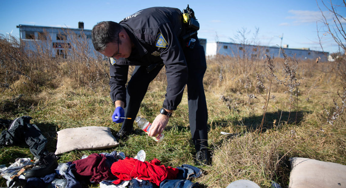 Officer Christian Bruckhart collects used needles from a vacant site in his patrol area in New Haven, Conn. CREDIT: RYAN CARON KING/CONNECTICUT PUBLIC RADIO