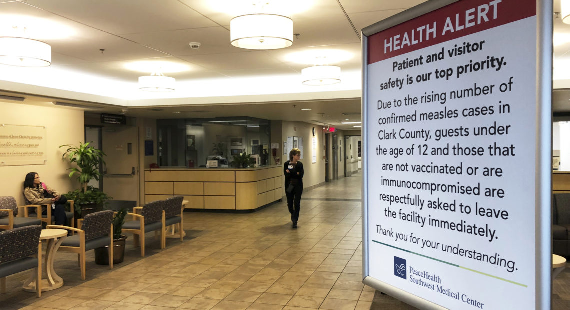 A sign prohibiting all children under 12 and unvaccinated adults stands at the entrance to PeaceHealth Southwest Medical Center in Vancouver, Wash. CREDIT: GILLIAN FLACCUS/AP