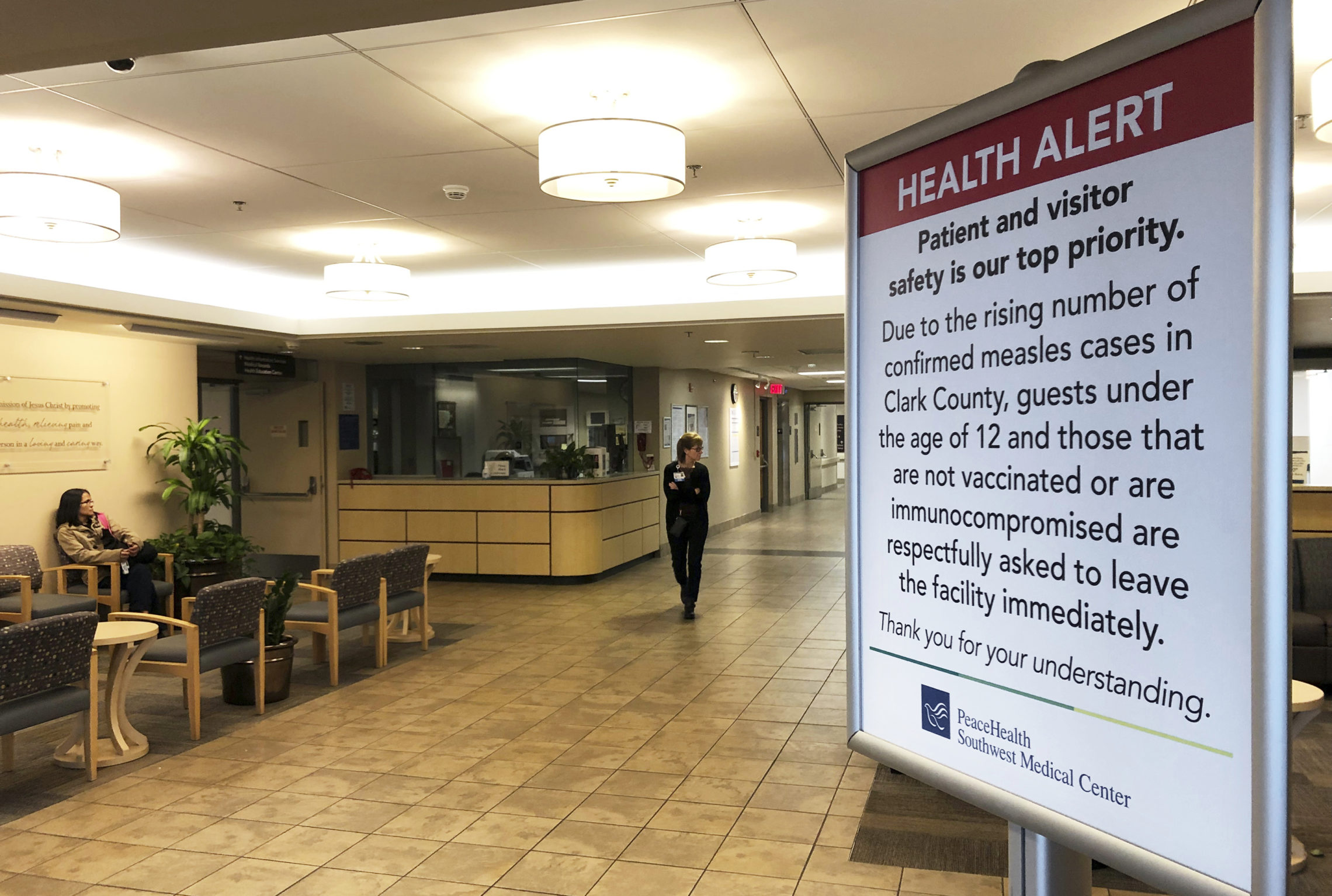 A sign prohibiting all children under 12 and unvaccinated adults stands at the entrance to PeaceHealth Southwest Medical Center in Vancouver, Wash. CREDIT: GILLIAN FLACCUS/AP