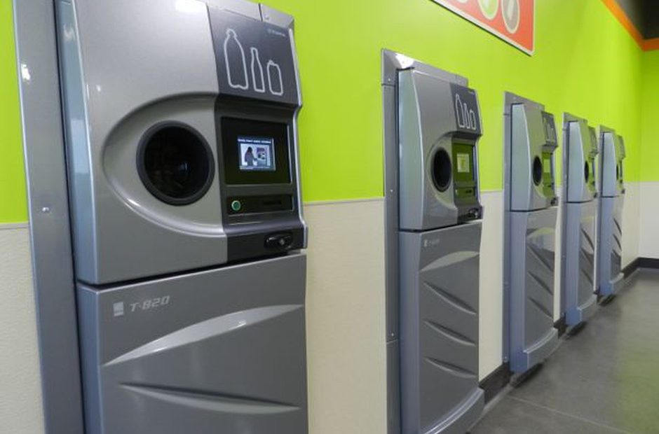 A row of sparkling clean reverse vending machines greet customers at the grand opening of the Medford BottleDrop center. CREDIT: JES BURNS/EARTHFIX