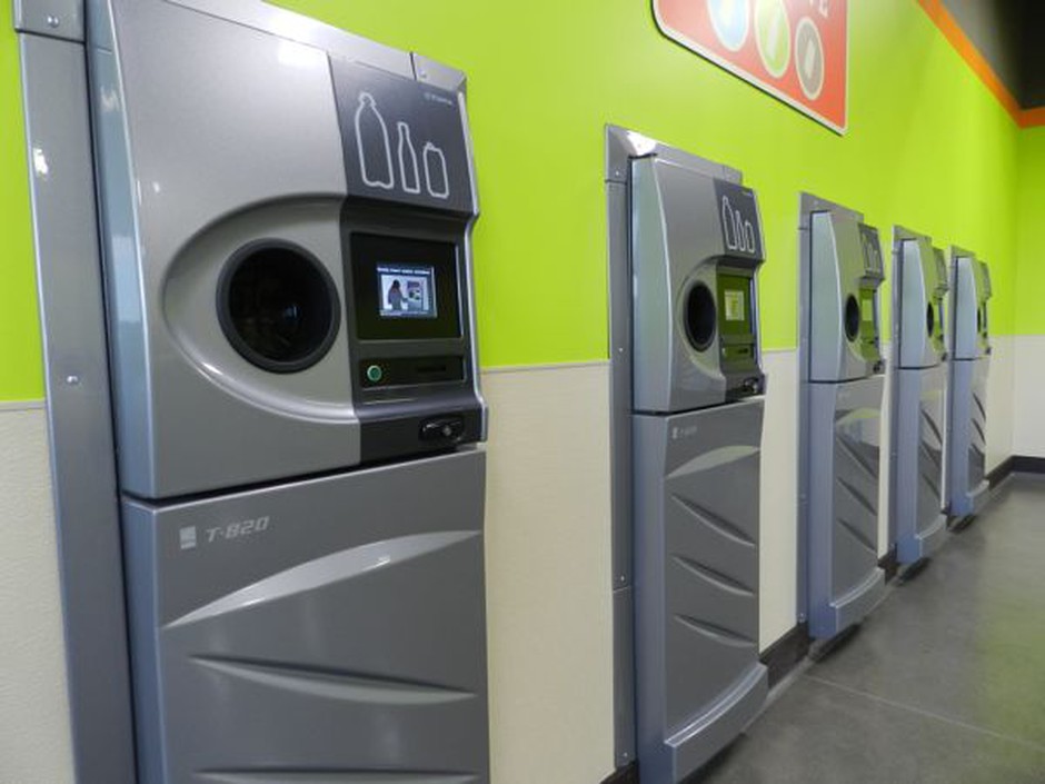 A row of sparkling clean reverse vending machines greet customers at the grand opening of the Medford BottleDrop center. CREDIT: JES BURNS/EARTHFIX