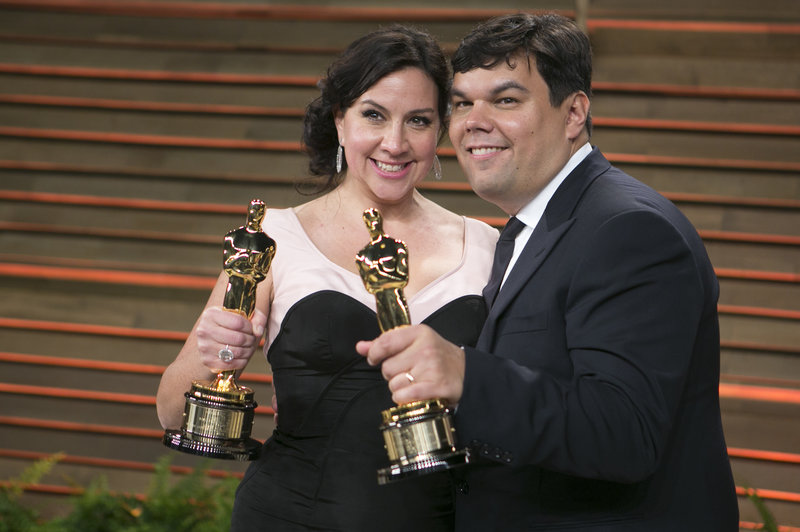 Kristen Anderson-Lopez and Robert Lopez arrive with their Academy Awards for best original song to the 2014 Vanity Fair Oscar Party in West Hollywood. Adrian Sanchez-Gonzalez/AFP/Getty Images
