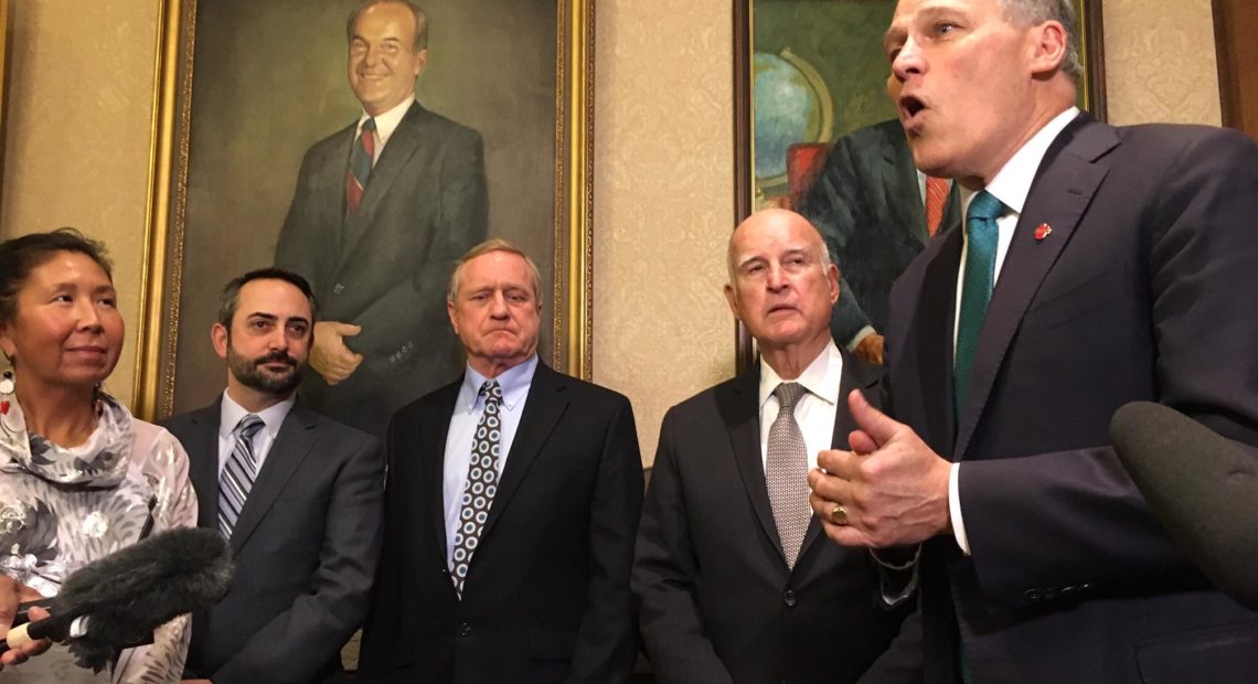 Gov. Jay Inslee speaks about climate change in the foyer of his office. On his right is former California Gov. Jerry Brown and state lawmakers. CREDIT: AUSTIN JENKINS / NW NEWS NETWORK