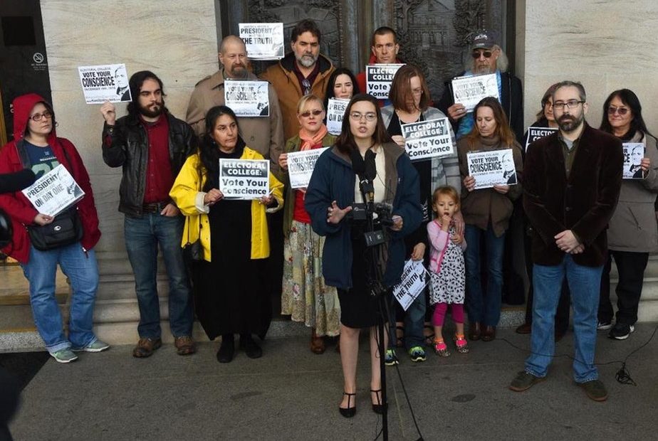 Washington state presidential elector Levi Guerra, center, joined by fellow elector P. Bret Chiafalo , right, announced in 2016 that they'd ask fellow members of the Electoral College to pick a Republican "consensus candidate" rather than Donald Trump. CREDIT: STEVE BLOOM/THE OLYMPIAN via AP