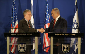 U.S. National Security Adviser John Bolton (left) and Israeli Prime Minister Benjamin Netanyahu shake hands during a joint statement to the media follow their meeting, in Jerusalem on Sunday. CREDIT: Oded Balilty/AP