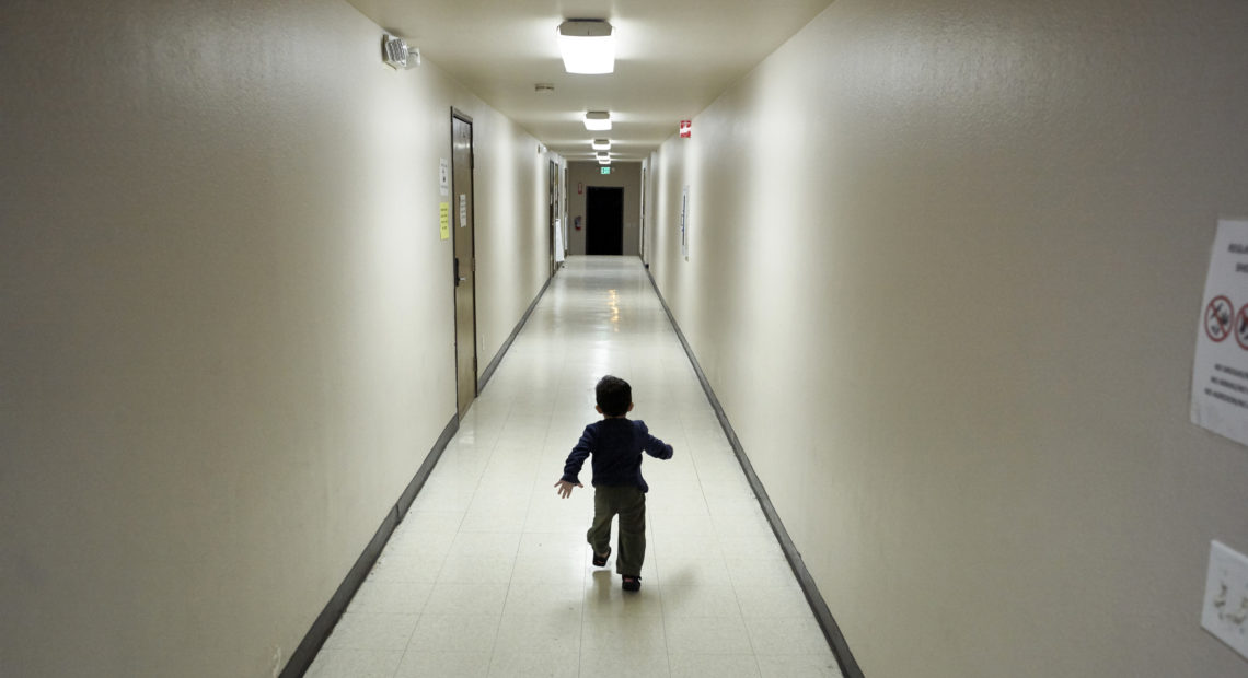 An asylum-seeking boy from Central America runs down a hallway in December after arriving at a shelter in San Diego. Immigrant advocates say they are suing the U.S. government for allegedly detaining immigrant children too long and improperly refusing to release them to relatives. CREDIT: GREGORY BULL/AP