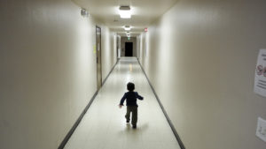 An asylum-seeking boy from Central America runs down a hallway in December after arriving at a shelter in San Diego. Immigrant advocates say they are suing the U.S. government for allegedly detaining immigrant children too long and improperly refusing to release them to relatives. CREDIT: GREGORY BULL/AP