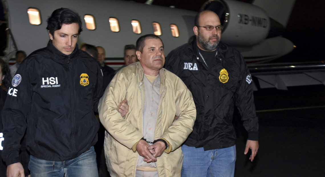 U.S. law enforcement personnel escort Joaquín "El Chapo" Guzmán from a plane to a waiting caravan of SUVs at New York's Long Island MacArthur Airport in January 2017. U.S. law enforcement via AP