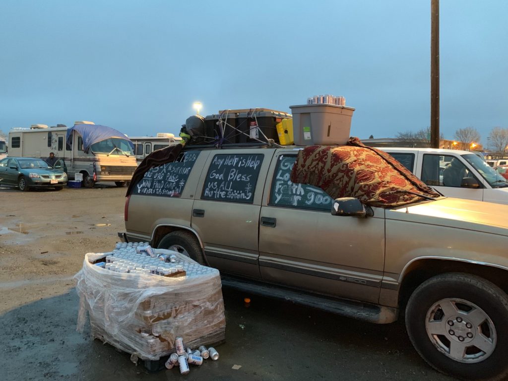 A message, written in white spray paint on a car window, says 'any help is help.' The car sits in the parking lot of a shelter in Chico where, more than two months after the fire, 700 victims still live. CREDIT: Kirk Siegler/NPR