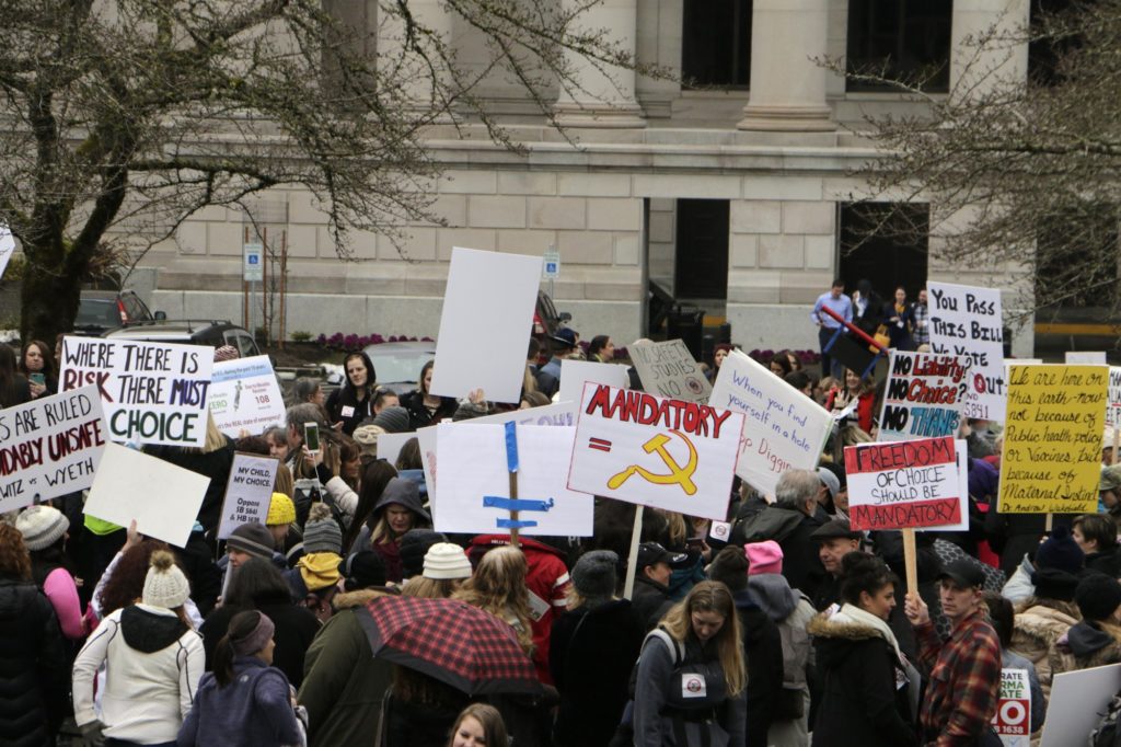 Opponents to efforts to remove philosophical exemptions from school-vaccine requirements rally outside the Washington Capitol, in Olympia, Wash., Wednesday, Feb. 20,2019. Lawmakers are considering two measures, one that would remove the exemption from the combined measles, mumps and rubella vaccine, and another that would not allow personal or philosophical exemptions to be granted for any required school vaccinations. CREDIT: RACHEL LA CORTE/AP