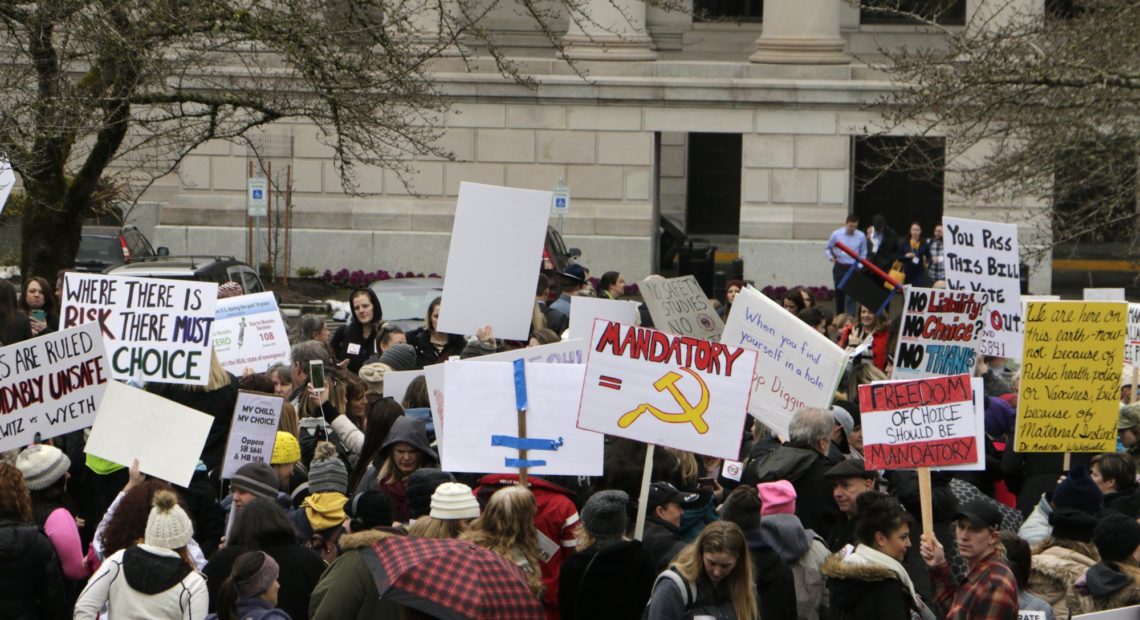 Opponents to efforts to remove philosophical exemptions from school-vaccine requirements rally outside the Washington Capitol, in Olympia, Wash., Wednesday, Feb. 20,2019. Lawmakers are considering two measures, one that would remove the exemption from the combined measles, mumps and rubella vaccine, and another that would not allow personal or philosophical exemptions to be granted for any required school vaccinations. CREDIT: RACHEL LA CORTE/AP