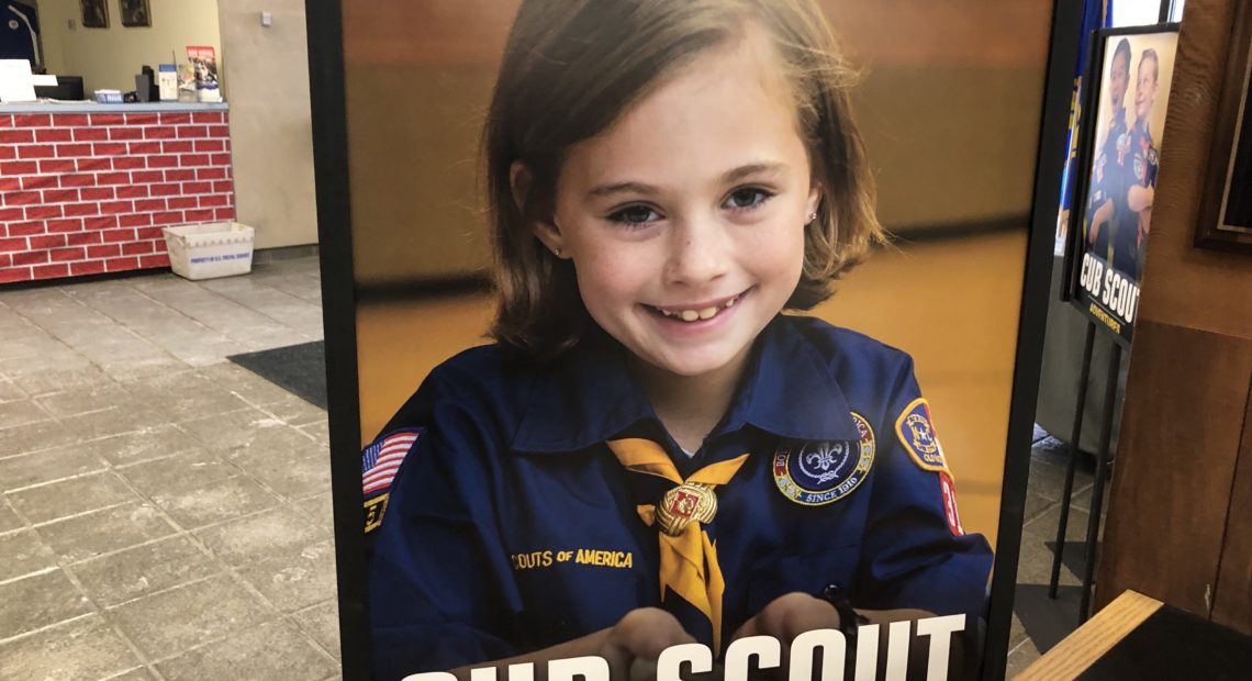 A poster at the entrance of the Laurel Highlands Council headquarters in Pittsburgh shows a young girl in a Cub Scouts uniform. The program for younger kids can include co-ed troops, but older kids will have single-sex troops. CREDIT: KATIE BLACKLEY/WESA