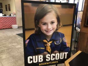 A poster at the entrance of the Laurel Highlands Council headquarters in Pittsburgh shows a young girl in a Cub Scouts uniform. The program for younger kids can include co-ed troops, but older kids will have single-sex troops. CREDIT: KATIE BLACKLEY/WESA