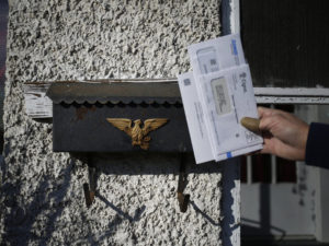 A U.S. Postal Service letter carrier delivers the mail in Shelbyville, Ky. A White House task force recommended ending the mailbox monopoly held by USPS. CREDIT: Luke Sharrett/Bloomberg via Getty Images