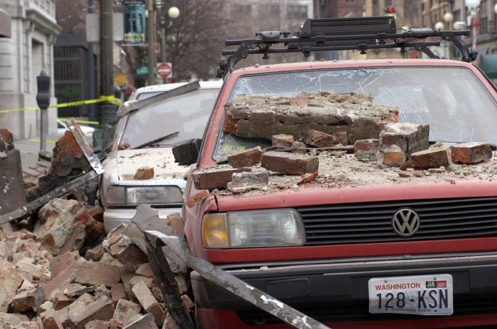 Fallen bricks cover parked cars in Seattle's Pioneer Square district after the 2001 Nisqually Earthquake. That magnitude 6.8 quake is the most recent one to cause significant damage and injuries in the Pacific Northwest. CREDIT: ELAINE THOMPSON/AP