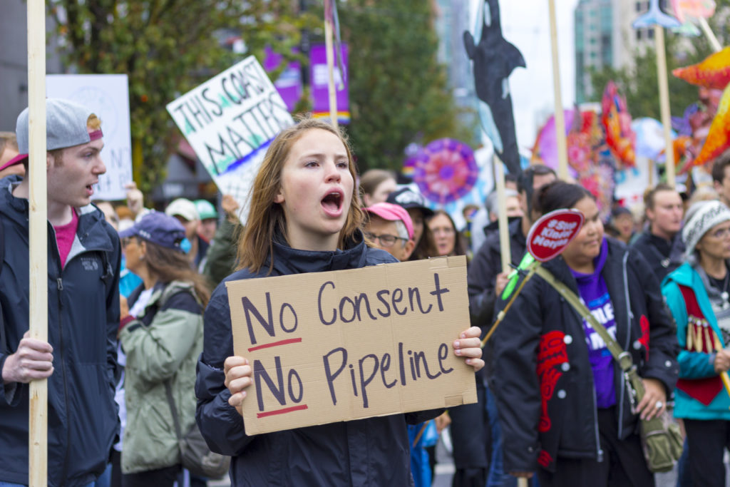 A protester holds a sign stating during a Kinder Morgan (Trans Mountain) Pipeline rally on Sept. 9, 2017 in Vancouver, Canada. CREDIT: WILLIAM CHEN/WIKIMEDIA/CREATIVE COMMONS