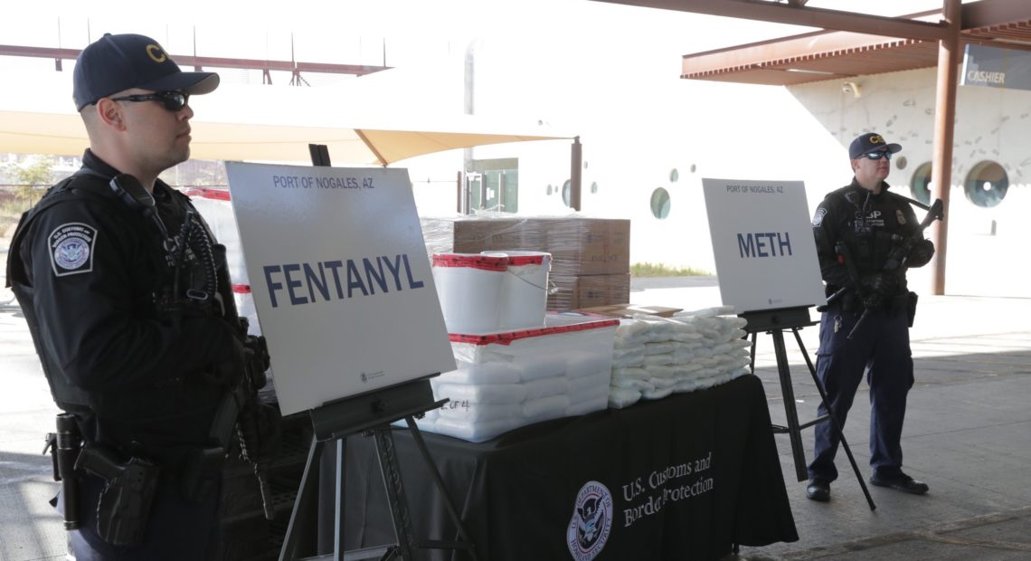 CBP agents, pictured Thursday, stand beside drugs seized last weekend at Arizona's Port of Nogales. CREDIT: U.S. CUSTOMS AND BORDER PROTECTION