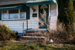 A home in the Lost Valley area of Manville, N.J. The numbers spray-painted on the front of the house indicate that it was bought as part of a federal disaster program. Claire Harbage/NPR