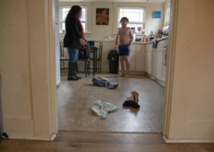 Landa tells Zach to collect his clothing from the kitchen floor of their home in Olympia after he returns home from school on Wednesday, Feb. 27, 2019. Zach typically prefers to not wear clothing, and likes to immediately take it off as soon as he returns home, Landa says. CREDIT: SHAUNA SOWERSBY / THE TACOMA NEWS TRIBUNE