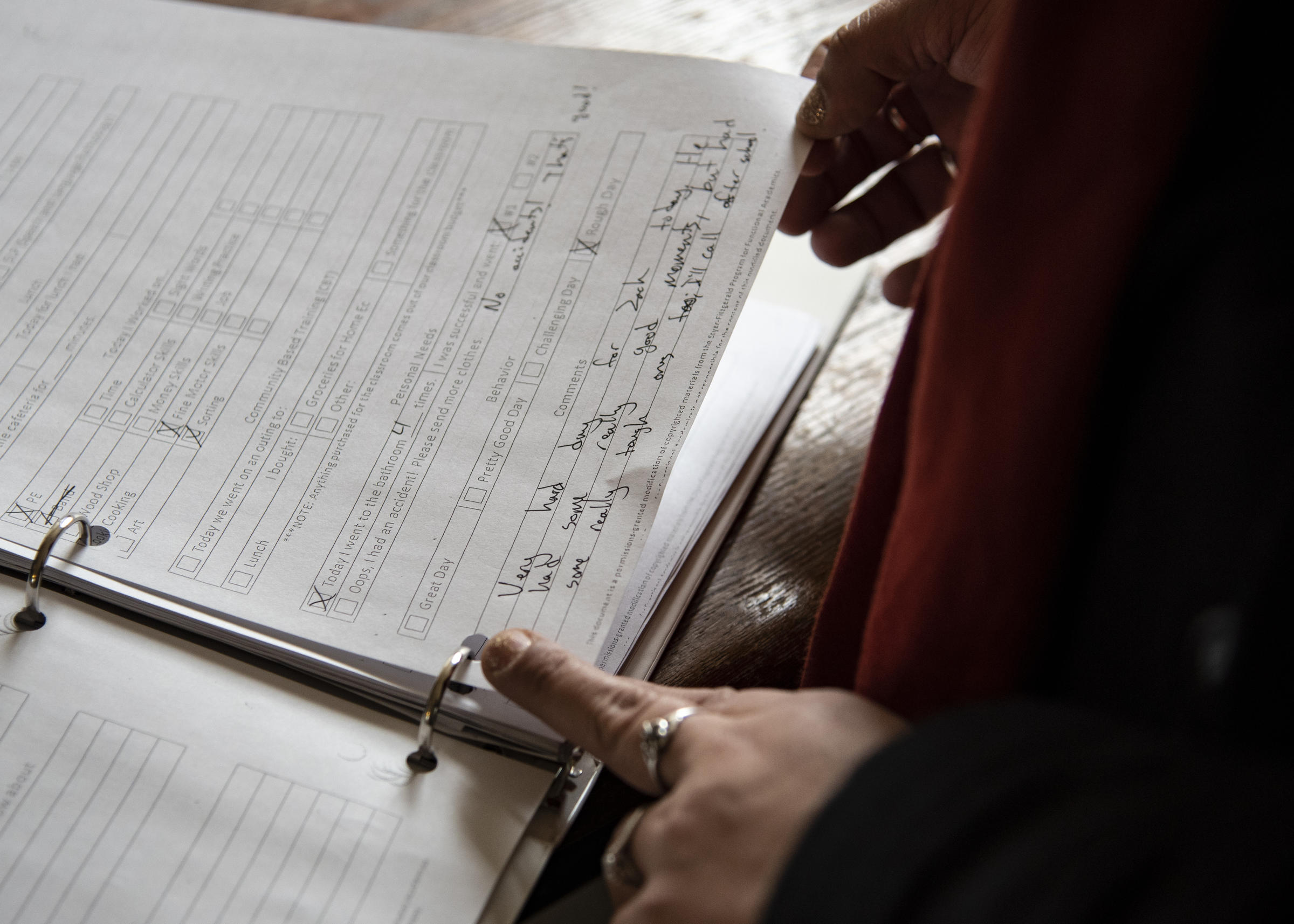 Landa reads a note from teachers on Wednesday, Feb. 27, 2019 that starts with, 'very hard day for Zach.' Because Landa isn't allowed to go to Zach's school, she must rely on notes passed on from his teachers to keep her updated on daily items such as behavior and progress. CREDIT: SHAUNA SOWERSBY / THE TACOMA NEWS TRIBUNE