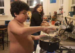 Zach stirs a pot of mashed potatoes as Landa washes dishes on Wednesday, Feb. 27, 2019. Landa said one of Zach's favorite things to do in the house is cook, so she gives him small tasks he can help with in the kitchen. CREDIT: SHAUNA SOWERSBY/ THE TACOMA NEWS TRIBUNE