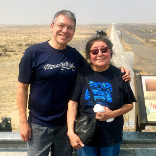 Physicist Corey Gray and his mother, Sharon Yellowfly, are pictured at one of the two massive detectors that make up the Laser Interferometer Gravitational-Wave Observatory. One facility, where Gray works, is in Hanford, Wash., and the other is in Louisiana. Courtesy of Russell Barber