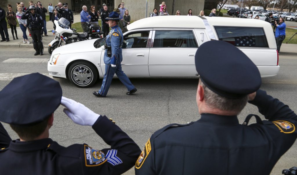 Law enforcement personnel salute as a hearse bearing the body of Kittitas County Deputy Sheriff Ryan Thompson arrives ahead of a memorial service at Central Washington University, Thursday, March 28, 2019. CREDIT: Jake Green/The Daily Record via AP