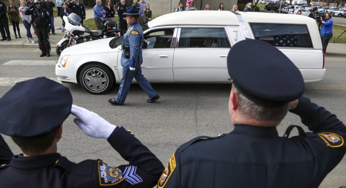 Law enforcement personnel salute as a hearse bearing the body of Kittitas County Deputy Sheriff Ryan Thompson arrives ahead of a memorial service at Central Washington University, Thursday, March 28, 2019. CREDIT: Jake Green/The Daily Record via AP