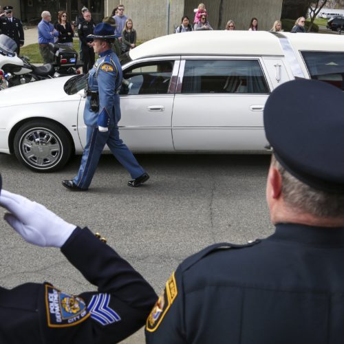 Law enforcement personnel salute as a hearse bearing the body of Kittitas County Deputy Sheriff Ryan Thompson arrives ahead of a memorial service at Central Washington University, Thursday, March 28, 2019. CREDIT: Jake Green/The Daily Record via AP