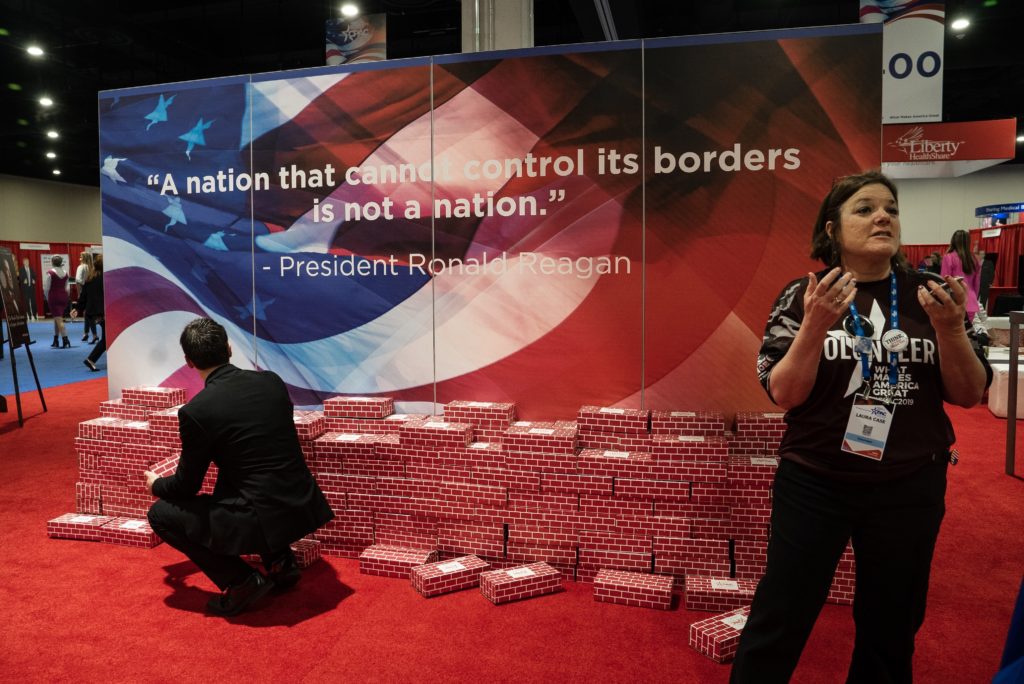 A fake wall, made of cardboard bricks, is on display with a quote by former President Ronald Reagan that reads: "A nation that cannot control its borders is not a nation." CREDIT: Amr Alfiky/NPR