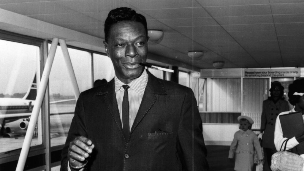 Nat 'King' Cole having a smoke while disembarking from a plane in 1963. Evening Standard/Getty Images