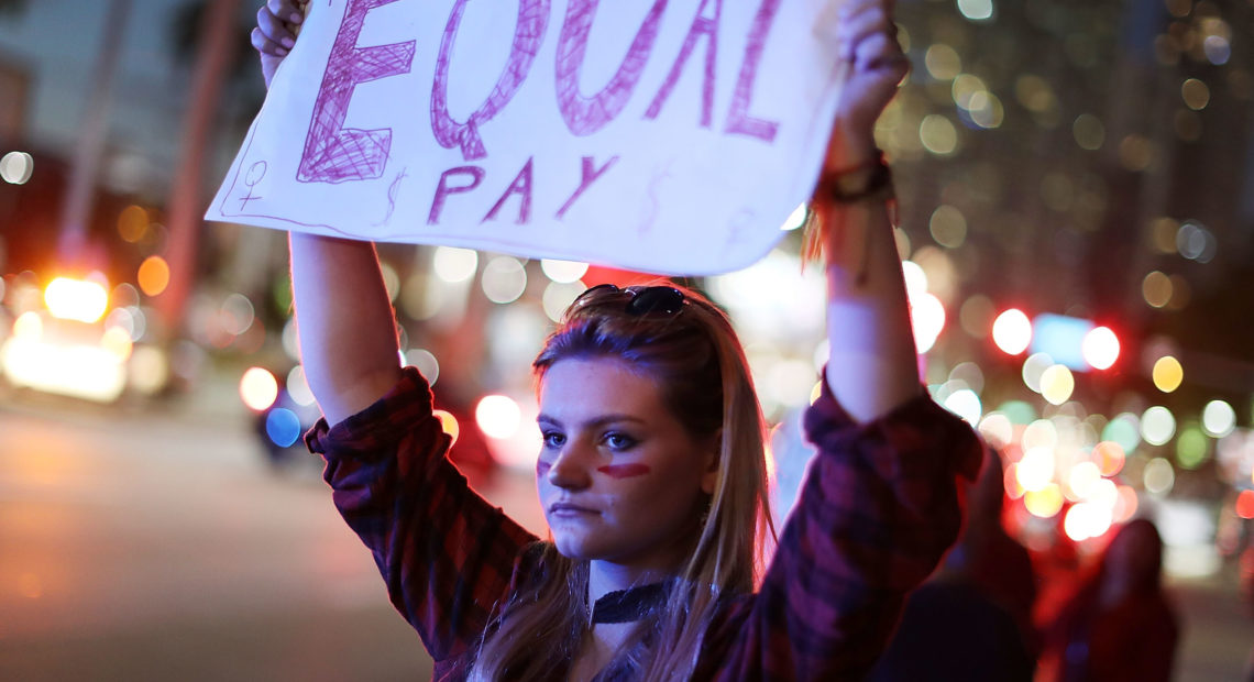 Clarissa Horsfall joins with others during "A Day Without A Woman" demonstration on March 8, 2017, in Miami. Employment attorneys say they've seen a spike in pay-disparity cases. CREDIT: Joe Raedle/Getty Images