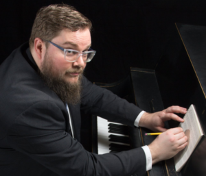 composer sitting at piano