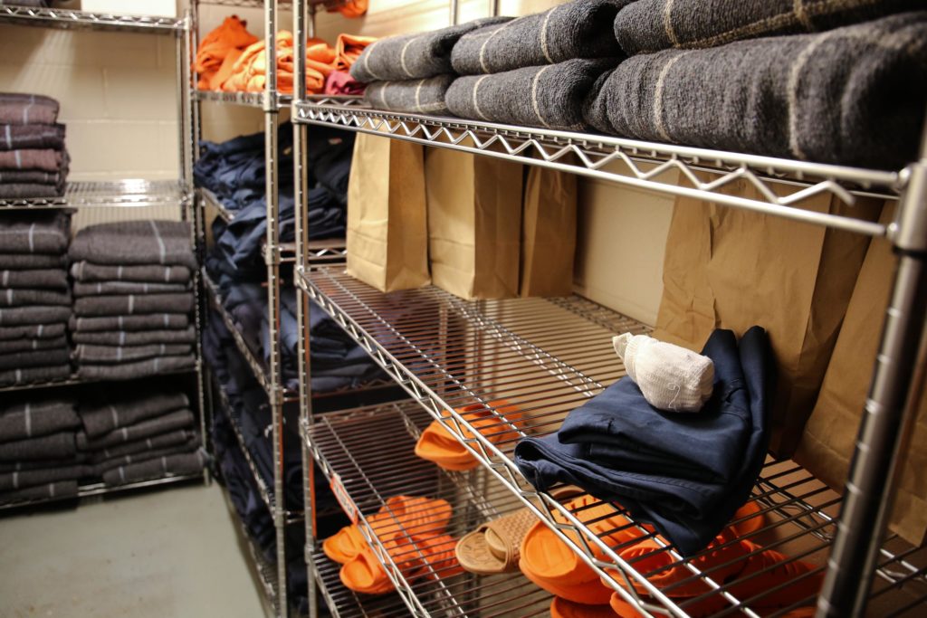 Socks, sandals, clothing and blankets line the shelves of a stock room at the Deschutes County Jail in Bend, Ore., Tuesday, March 12, 2019. In Oregon, jails must comply with a set of statewide standards that govern everything from riot control to a requirement that mattresses and blankets be fire-retardant. CREDIT: Emily Cureton/OPB